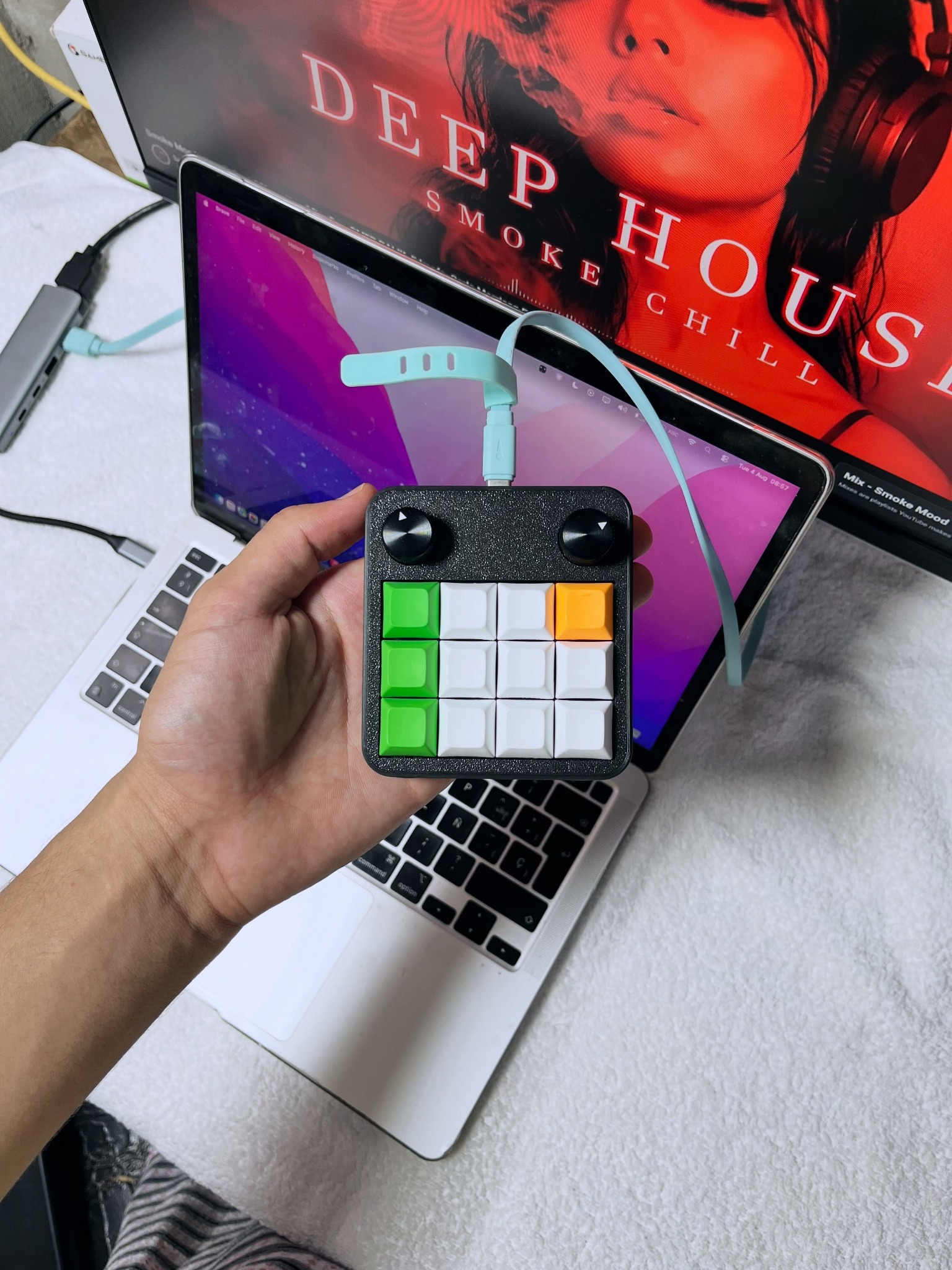 Macro Pad held in hand beside a laptop